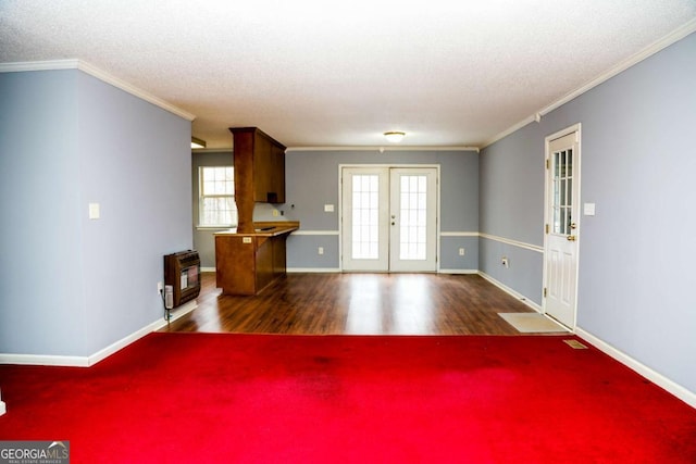 interior space with dark hardwood / wood-style flooring, heating unit, french doors, a textured ceiling, and ornamental molding