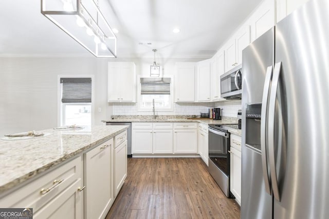 kitchen featuring hanging light fixtures, dark hardwood / wood-style flooring, appliances with stainless steel finishes, white cabinets, and tasteful backsplash