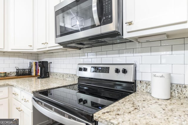 kitchen with white cabinets, decorative backsplash, and appliances with stainless steel finishes