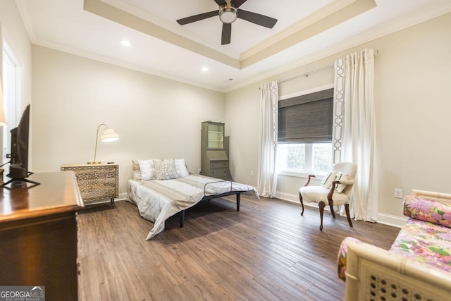 bedroom featuring crown molding, dark wood-type flooring, ceiling fan, and a raised ceiling