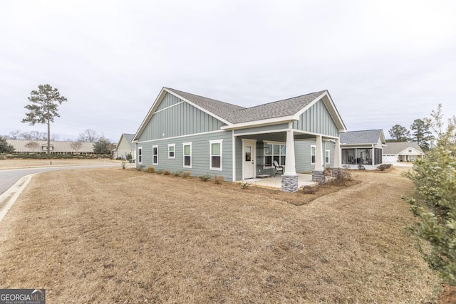 view of property exterior with a porch and a lawn