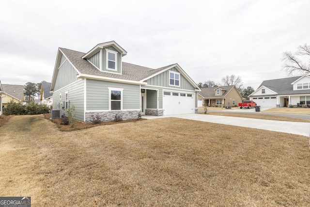 view of front of property with a garage, central air condition unit, and a front lawn