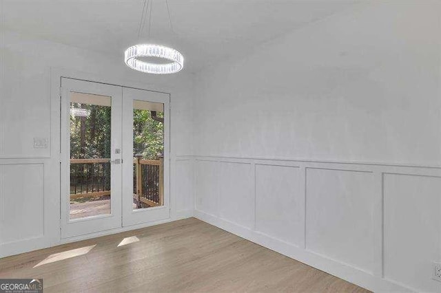 unfurnished dining area featuring light wood-type flooring, a healthy amount of sunlight, and french doors