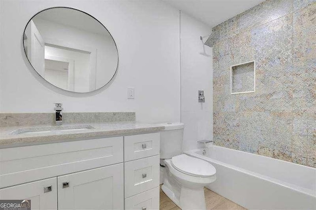 full bathroom with tiled shower / bath combo, vanity, and toilet