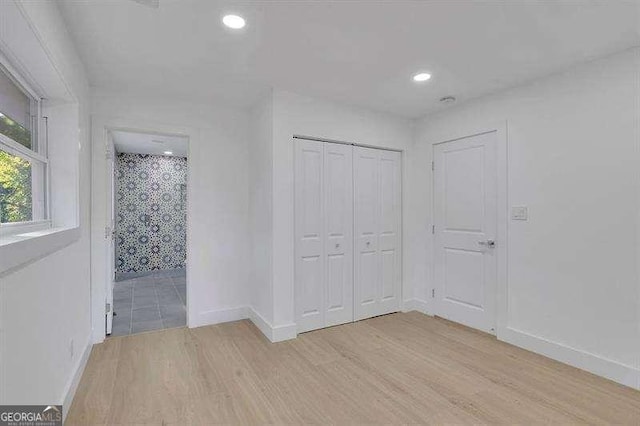 unfurnished bedroom featuring a closet and light hardwood / wood-style floors