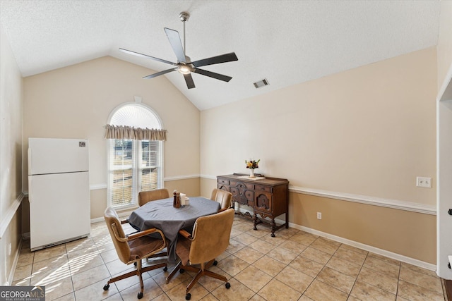 tiled dining area featuring ceiling fan, a textured ceiling, and vaulted ceiling