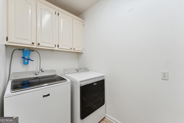 laundry room with washing machine and dryer and cabinets