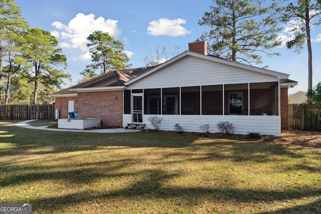 back of house featuring a yard and a sunroom