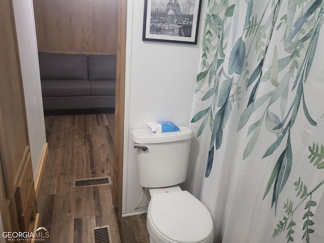 bathroom with hardwood / wood-style flooring and toilet