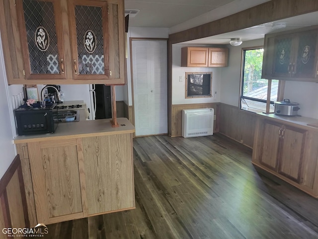 kitchen featuring kitchen peninsula, heating unit, and dark hardwood / wood-style floors