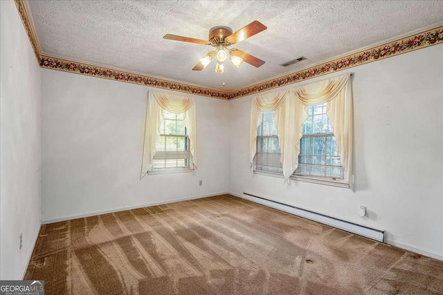 empty room with a textured ceiling, a baseboard heating unit, carpet, and a healthy amount of sunlight