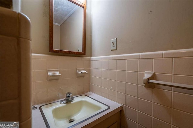 bathroom with ornamental molding, tile walls, and vanity