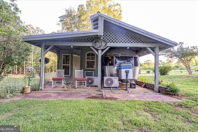 rear view of house featuring ac unit and a lawn