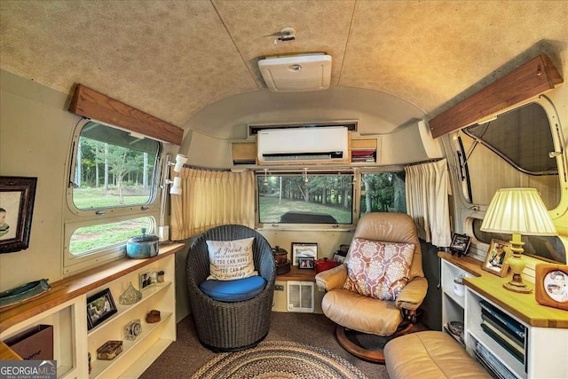 sitting room with vaulted ceiling, brick ceiling, and an AC wall unit