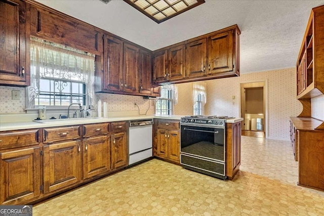 kitchen with kitchen peninsula, white dishwasher, a textured ceiling, black range with gas stovetop, and sink