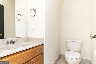 bathroom featuring toilet, tile patterned floors, and vanity