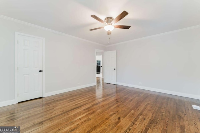 empty room featuring ceiling fan, crown molding, and wood-type flooring