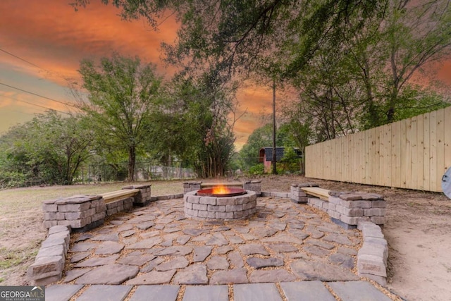 patio terrace at dusk featuring a fire pit