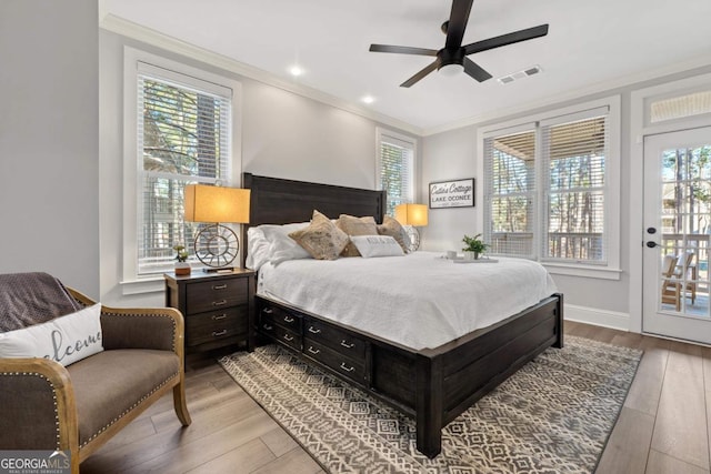 bedroom featuring ceiling fan, access to exterior, crown molding, and multiple windows