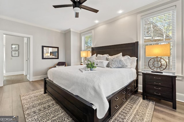 bedroom featuring ceiling fan, ornamental molding, light hardwood / wood-style flooring, and multiple windows