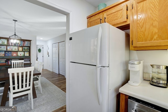 kitchen with hardwood / wood-style floors, beverage cooler, decorative light fixtures, white refrigerator, and an inviting chandelier