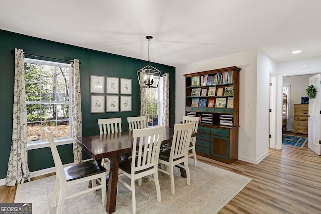 dining room featuring light wood-type flooring and an inviting chandelier