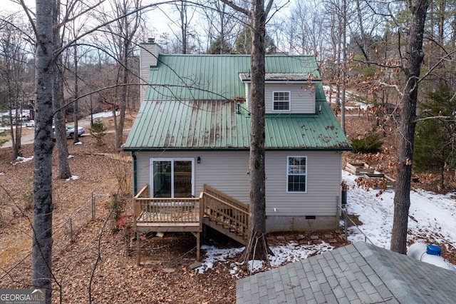 snow covered rear of property with a wooden deck