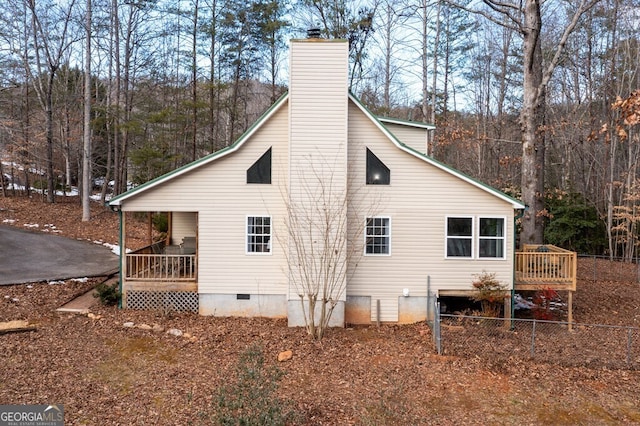 view of side of home with covered porch and a deck