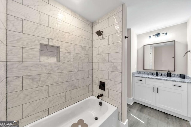 bathroom featuring tiled shower / bath, vanity, and hardwood / wood-style floors