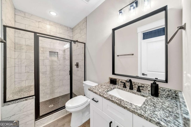 bathroom with toilet, hardwood / wood-style flooring, an enclosed shower, and vanity