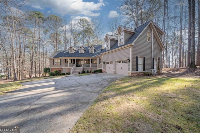 new england style home featuring a garage, a front yard, and a porch