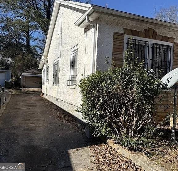 view of property exterior featuring a garage and an outbuilding