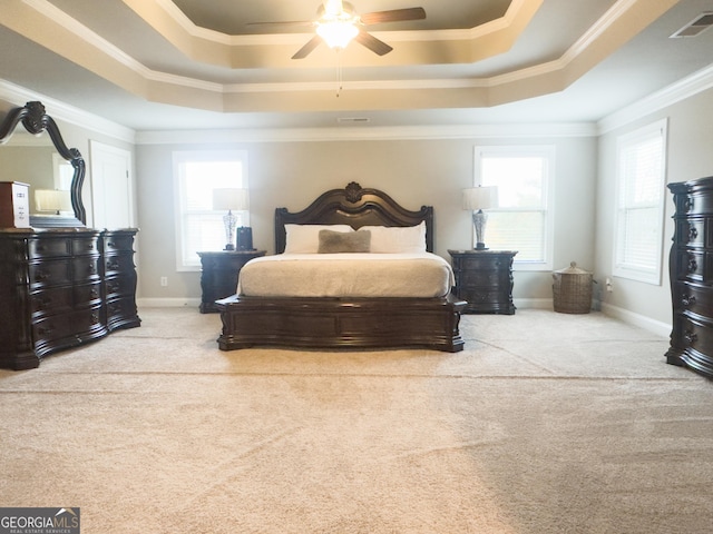 bedroom with ceiling fan, light carpet, ornamental molding, and a raised ceiling