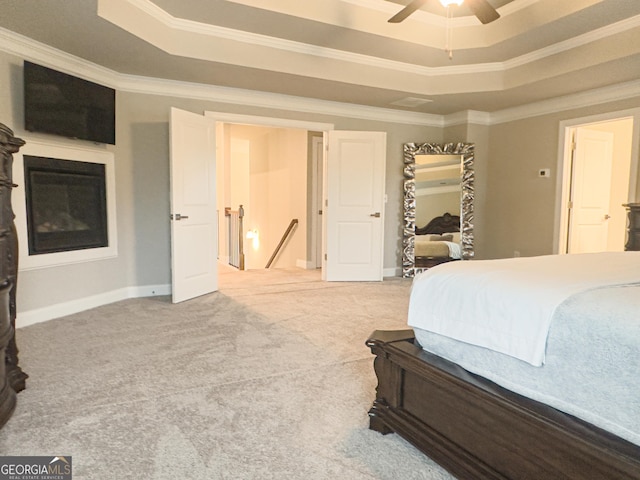 bedroom with ceiling fan, a tray ceiling, and crown molding