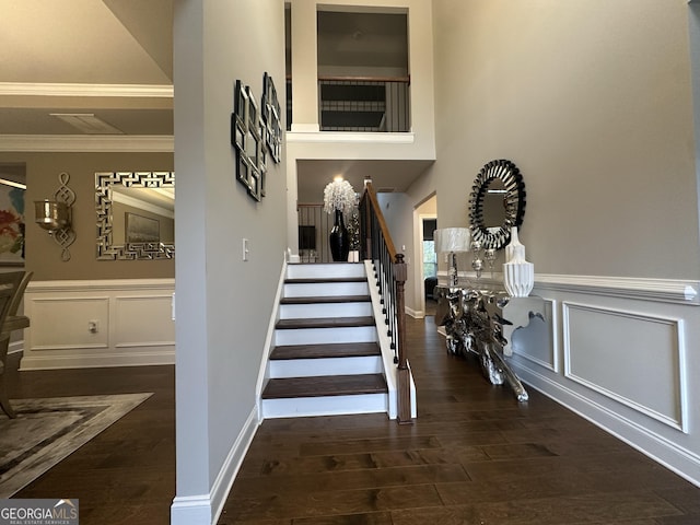 stairs with wood-type flooring and crown molding