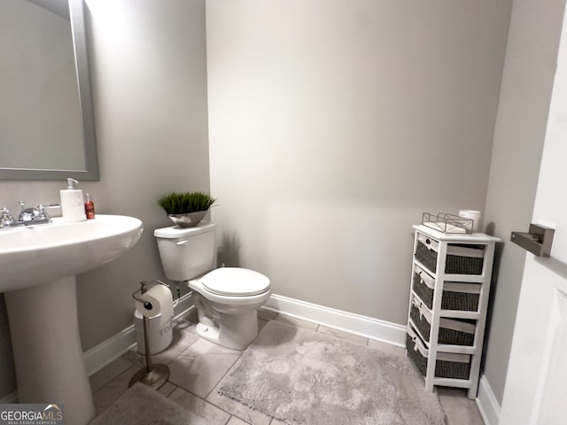 bathroom with sink, toilet, and tile patterned flooring