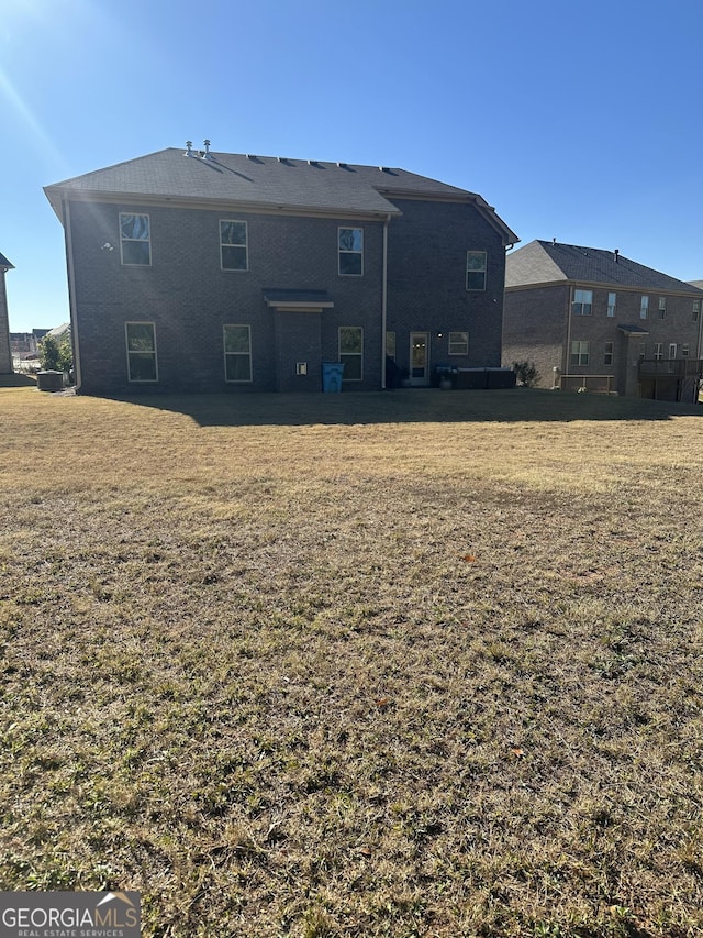 rear view of property featuring a lawn