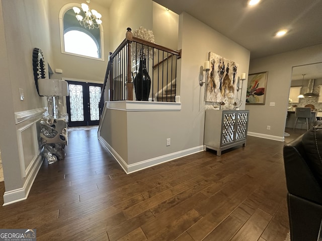 foyer entrance with dark hardwood / wood-style flooring, a chandelier, and french doors