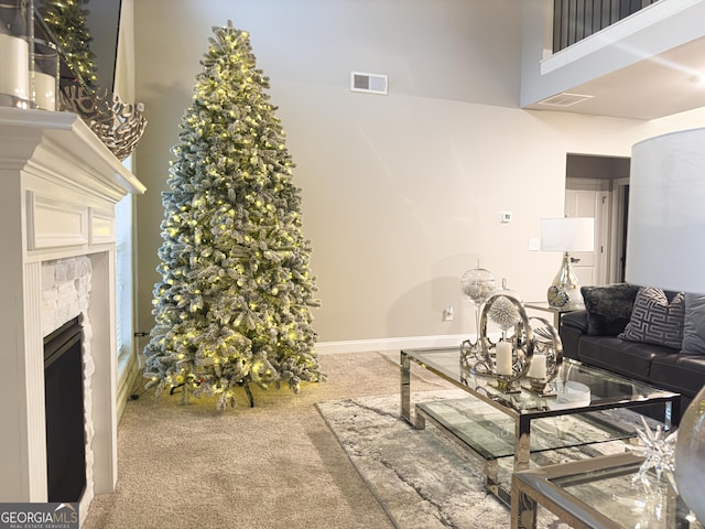 carpeted living room featuring a towering ceiling