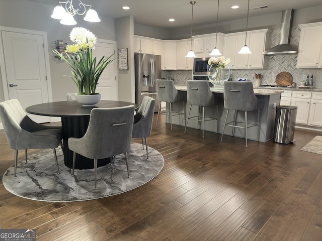 dining space with dark wood-type flooring and a chandelier