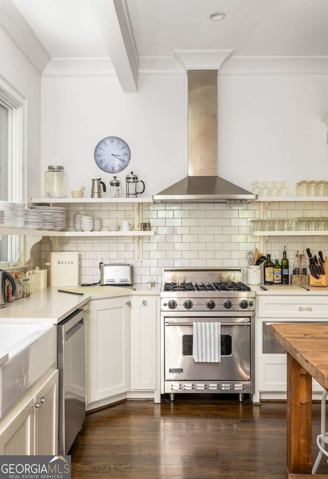 kitchen featuring backsplash, wall chimney range hood, appliances with stainless steel finishes, and white cabinets