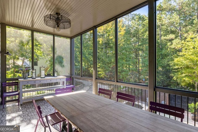 unfurnished sunroom featuring ceiling fan and plenty of natural light