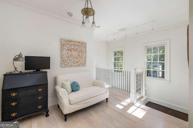 sitting room featuring rail lighting, light hardwood / wood-style flooring, and ornamental molding