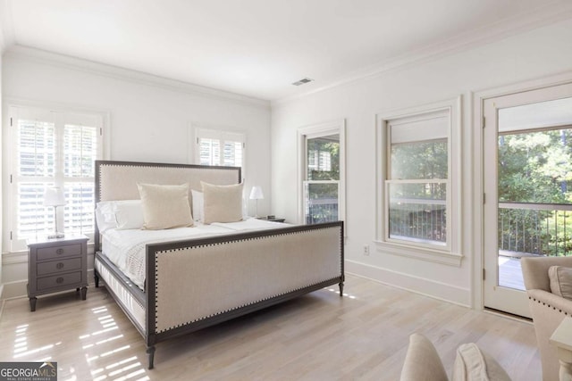 bedroom featuring light hardwood / wood-style floors, access to exterior, multiple windows, and crown molding