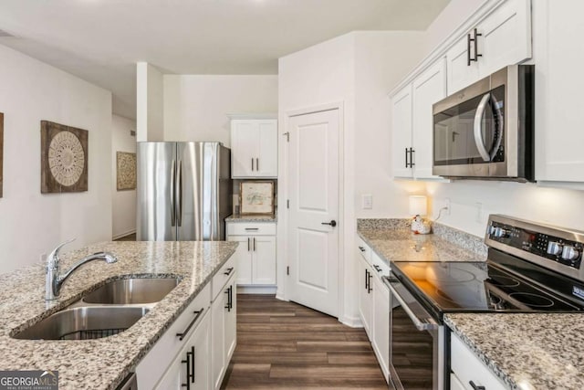 kitchen featuring light stone countertops, appliances with stainless steel finishes, sink, and white cabinetry