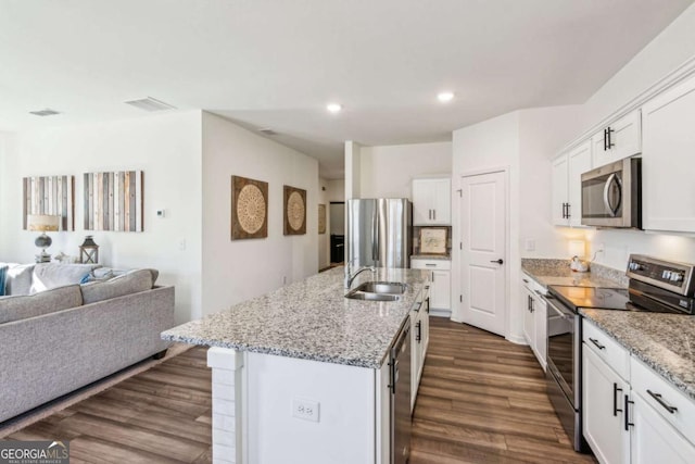 kitchen featuring white cabinets, stainless steel appliances, sink, dark hardwood / wood-style floors, and a center island with sink