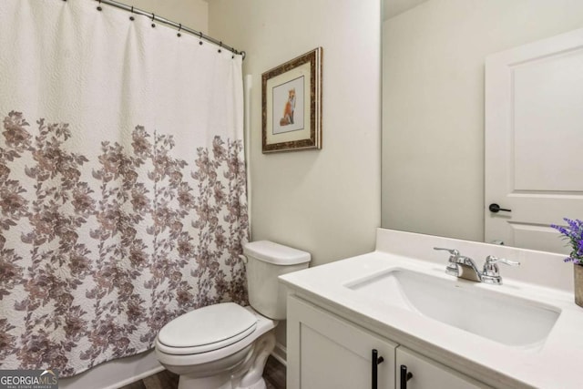 bathroom featuring toilet, vanity, and a shower with shower curtain