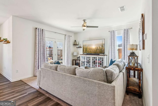 living room featuring ceiling fan and dark wood-type flooring