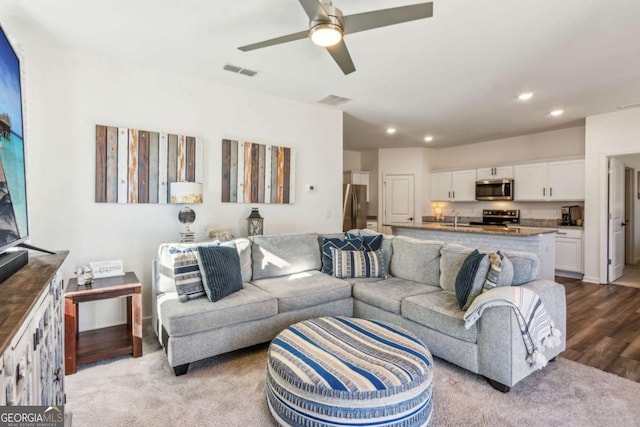 carpeted living room with ceiling fan