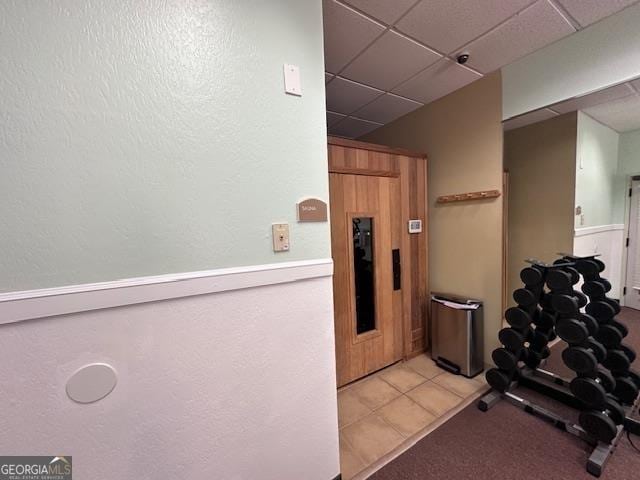 interior space featuring dark colored carpet, wood ceiling, and ceiling fan